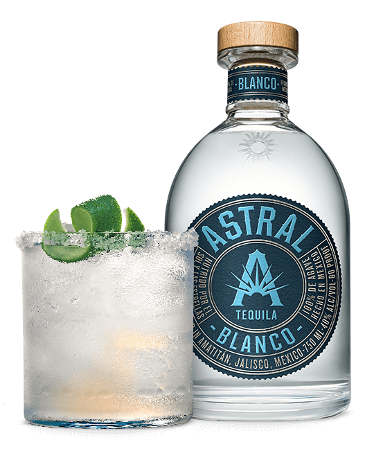 Bottle of Astral Tequila and drink with lime twist to the side
